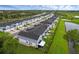 Modern townhome community with uniform architecture, green spaces, and a pond nearby, showcasing a cohesive neighborhood design at 1932 Terrapin Rd, Ocoee, FL 34761