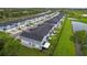 Planned community of modern townhomes with black roofs, fenced yards, and green spaces, offering a cohesive and appealing aesthetic at 1932 Terrapin Rd, Ocoee, FL 34761