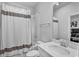 Bright bathroom features a shower-tub combo with a striped shower curtain and a single sink vanity at 1932 Terrapin Rd, Ocoee, FL 34761