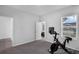 Carpeted exercise room with exercise bike next to an open doorway with neutral walls and natural light at 1932 Terrapin Rd, Ocoee, FL 34761