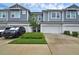 Charming exterior view of townhomes, featuring muted blue siding, a two-car garage, and landscaping at 1932 Terrapin Rd, Ocoee, FL 34761
