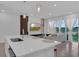 Modern kitchen island with sink overlooks a living room with television and fireplace at 1932 Terrapin Rd, Ocoee, FL 34761