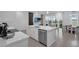 Modern kitchen with a sink in the island, stainless dishwasher, and an open living and dining room at 1932 Terrapin Rd, Ocoee, FL 34761