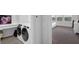 Laundry room with side-by-side washer and dryer next to a bedroom featuring neutral walls and a carpeted floor at 1932 Terrapin Rd, Ocoee, FL 34761
