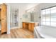 Bright bathroom featuring a glass shower, soaking tub, and double vanity sinks and a linen closet at 1932 Westpointe Cir, Orlando, FL 32835