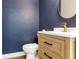 Stylish powder room featuring a navy textured wall, updated vanity and a round mirror at 1932 Westpointe Cir, Orlando, FL 32835
