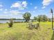 Serene backyard with patio seating overlooking a tranquil lake and lush green lawn at 2105 Lake Side Ave, Davenport, FL 33837