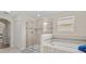 Bright bathroom with a glass shower, a soaking tub with tiled surround, and a large window at 2105 Lake Side Ave, Davenport, FL 33837