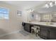 Bathroom with dual sinks, dark cabinetry, a large mirror, and natural light at 2105 Lake Side Ave, Davenport, FL 33837