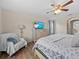 Bright bedroom featuring a ceiling fan, wood floors, a dresser with a TV, and a comfortable chair at 2105 Lake Side Ave, Davenport, FL 33837
