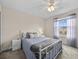 Cozy bedroom with a white metal bed frame, soft blue bedding, and natural light from the window at 2105 Lake Side Ave, Davenport, FL 33837