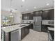 Open kitchen featuring dark wood cabinets, stainless steel appliances, and an island with a sink at 2105 Lake Side Ave, Davenport, FL 33837