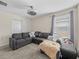Living room with a gray sectional couch, a ceiling fan, a window, and neutral carpet at 2105 Lake Side Ave, Davenport, FL 33837