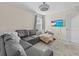 Comfortable living room featuring a gray sectional sofa and a modern ceiling fan with light at 2105 Lake Side Ave, Davenport, FL 33837