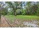Expansive backyard with lush green grass and mature trees offers plenty of space at 2180 Captain Dr, Deltona, FL 32738