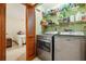 Convenient laundry room boasts modern washer and dryer set, storage shelves, and access to an additional room at 2180 Captain Dr, Deltona, FL 32738