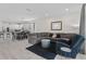 Open-concept living room with gray sectional, modern decor, and seamless access to dining and kitchen at 2339 Jernigan Loop, Kissimmee, FL 34746