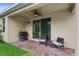 A covered patio with chairs, grill, and brick flooring offers relaxed outdoor living at 2339 Jernigan Loop, Kissimmee, FL 34746