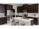 Modern kitchen featuring dark cabinets, stainless steel appliances, a white countertop island, and bar stool seating at 3021 Namaste Dr, Clermont, FL 34714
