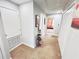Hallway with carpet, white walls and white doors and view into bedroom with orange couch at 3118 Crown Jewel Ct, Winter Park, FL 32792