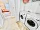 Bright laundry room with white washer and dryer and adjacent doorway to living area at 3118 Crown Jewel Ct, Winter Park, FL 32792