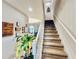 Carpeted stairs with white railing, adjacent to a living area with decorative wall art at 3118 Crown Jewel Ct, Winter Park, FL 32792