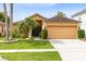 Charming single-story home featuring a manicured lawn, mature landscaping, and a two-car garage at 3224 Holland Dr, Orlando, FL 32825