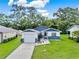 Aerial view of a charming home with a lush green lawn and a driveway leading to a single-car garage at 324 James Pl, St Cloud, FL 34769
