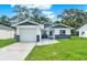 Charming single-story home featuring a well-manicured lawn and a modern two-tone color scheme at 324 James Pl, St Cloud, FL 34769