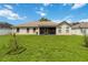 Spacious backyard featuring lush green grass and a beige house at 3250 Sawgrass Creek Cir, St Cloud, FL 34772