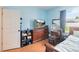 Cozy bedroom with light blue walls, wood floors and a dresser with a television at 3250 Sawgrass Creek Cir, St Cloud, FL 34772