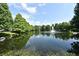 Scenic pond view featuring a water fountain surrounded by lush green trees under a blue sky at 335 Lansbrook Ln, Winter Springs, FL 32708