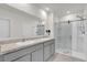 Sleek bathroom featuring dual sinks, a large mirror, and a glass-enclosed shower with built-in shelving at 336 Pelham Park Dr, Deland, FL 32720