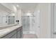 Modern bathroom featuring a double vanity, a large mirror, and a glass-enclosed shower at 336 Pelham Park Dr, Deland, FL 32720
