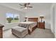Cozy bedroom with a wood sleigh bed, ottoman, and bright natural light from the large window at 336 Pelham Park Dr, Deland, FL 32720