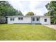 Exterior shot of a white single-story home with a large front yard at 3410 Calumet Dr, Orlando, FL 32810