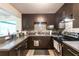 Well-equipped kitchen with stainless steel appliances, dark brown cabinets, and stylish backsplash at 3410 Calumet Dr, Orlando, FL 32810