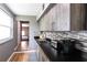 Kitchenette featuring gray cabinets, a stainless steel sink, a backsplash, and wood floors at 3410 Calumet Dr, Orlando, FL 32810