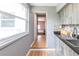 Kitchenette with gray cabinets, a black counter, a stainless steel sink, and wood floors at 3410 Calumet Dr, Orlando, FL 32810