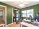 Home office with green walls, natural light, modern furnishings, and a closet for storage at 3410 Calumet Dr, Orlando, FL 32810