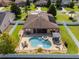 Backyard oasis features a sparkling pool, spa, pergola, and ample seating within a fenced yard at 3562 Foxchase Dr, Clermont, FL 34711