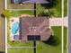 Aerial view of the home featuring a backyard pool, solar panels, fenced-in backyard, and patio area at 3562 Foxchase Dr, Clermont, FL 34711