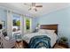 Bright bedroom with wood floors, backyard views, and white linens at 3562 Foxchase Dr, Clermont, FL 34711