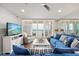 Coastal living room features a blue sofa, balcony access, and ocean views at 4621 S Atlantic Ave # 7202, Port Orange, FL 32127