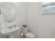 Powder room featuring pedestal sink, toilet, and window at 4759 Riverwalk Dr, St Cloud, FL 34771