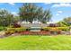 Landscaped entrance to The Preserve at Turtle Creek with manicured flowerbeds and mature trees at 4759 Riverwalk Dr, St Cloud, FL 34771