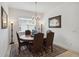 The dining room showcases neutral decor, featuring a round table, traditional chandelier, and ample natural light at 4759 Riverwalk Dr, St Cloud, FL 34771