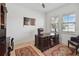 A home office boasts a large desk, leather chair, area rugs, and natural light from two windows at 4759 Riverwalk Dr, St Cloud, FL 34771