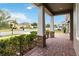 Inviting covered porch with brick flooring, stone-based columns, and lush landscaping at 4759 Riverwalk Dr, St Cloud, FL 34771