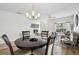 Open dining and living area featuring mixed flooring types, a stylish chandelier, and ample lighting at 504 Key Haven Dr, Sanford, FL 32771